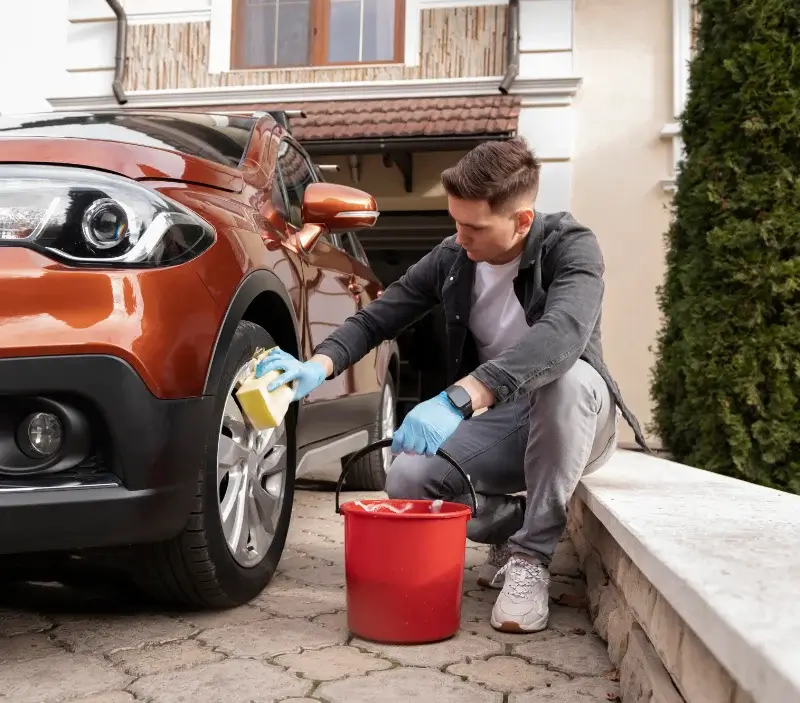 Lavage auto à domicile Saint-Germain-la-Campagne : professionnel intervenant sur un véhicule